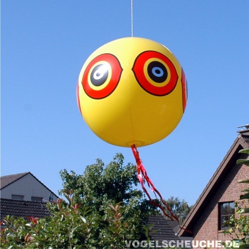 Der Vogelscheuch-Ballon hängt vor einem Wohnhaus und hält Vögel im siedlungsnahen Bereich fern.