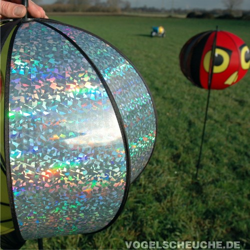 Nahaufnahme der silbrig reflektierenden Hologramm-Halbschale einer Turbinenlamelle, im Hintergrund ein roter Rotor.