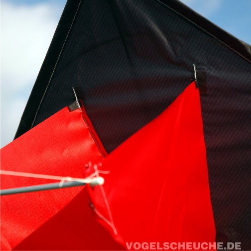 Detail der Kielbefestigung: roter Kiel, schwarzes Spinnakersegel und Spreizstab am Vogelscheuchdrachen.